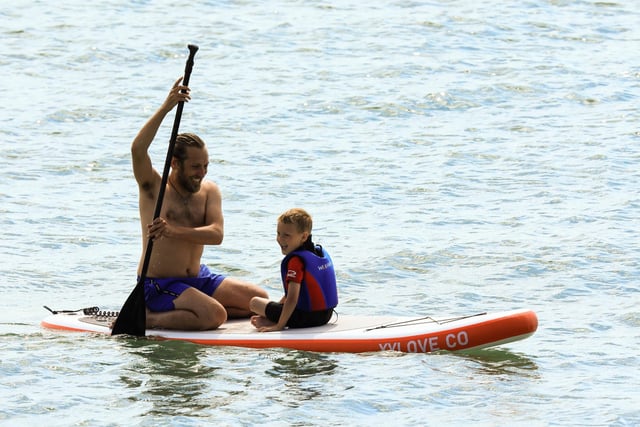 A pair enjoying a laugh on a paddle-board during the hot weather weekend.