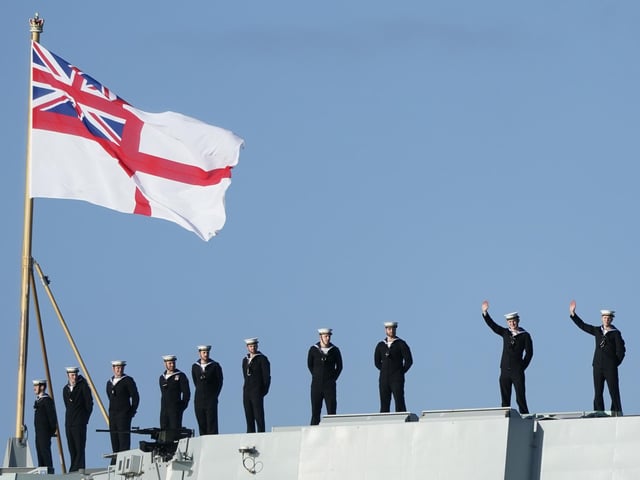 Sailors wave from the stern of the Royal Navy aircraft carrier HMS Prince of Wales as it returns to Portsmouth Naval Base following a three-month deployment to the Eastern Seaboard of the United States, where the Prince of Wales has been undergoing trials and operating with aircraft and drones. Picture: Andrew Matthews/PA Wire.