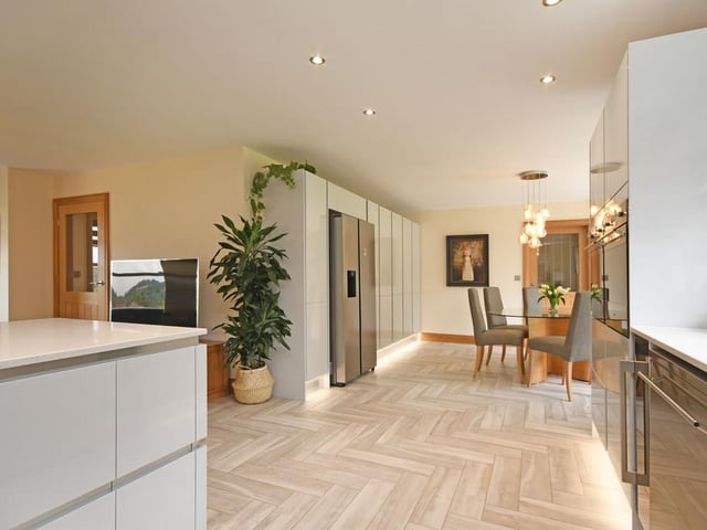 The kitchen itself has an impressive range of wall and base units in a light grey, high gloss finish complimented with a granite worktop with sink and drainer inset.