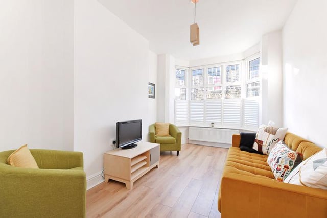 The living room has a bay window which is fitted with custom made wooden blinds.