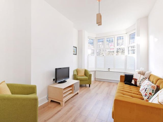 The living room has a bay window which is fitted with custom made wooden blinds.