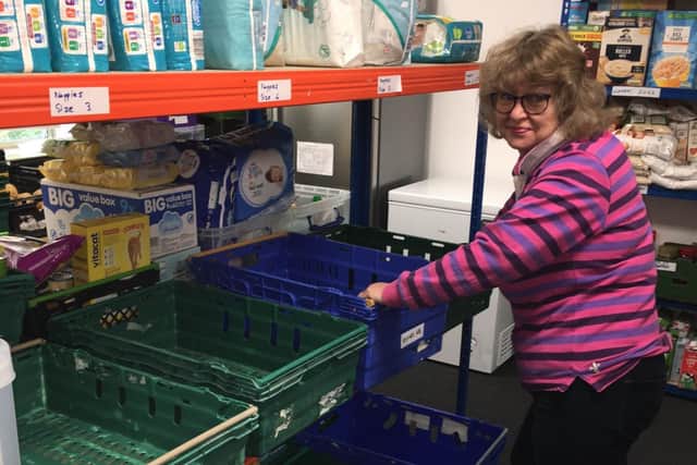Volunteer Belinda Davis with empty baskets at Acts of Kindness.