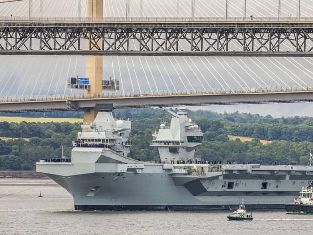 HMS Queen Elizabeth passes under the Forth Bridges as she heads back to sea following lengthy time at Rosyth for repairs and upgrades due to mechanical fault.    July 22, 2024.