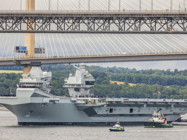 HMS Queen Elizabeth passes under the Forth Bridges as she heads back to sea following lengthy time at Rosyth for repairs and upgrades due to mechanical fault. July 22, 2024.