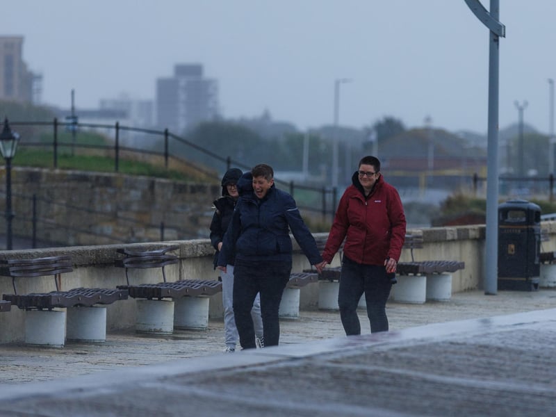 The stormy sea at high tide crashed waves onto footpaths as passer-by's did their best to get out the way