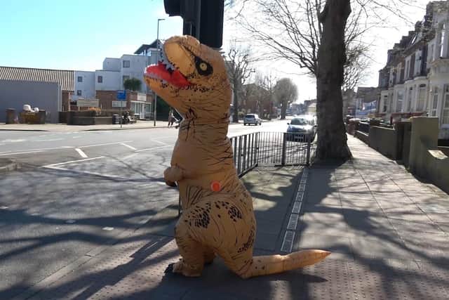 Hannah Pilcher, 29, of North End dresses up as a dinosaur to entertain children in Portsmouth during lockdown. Pictured waiting at a traffic light