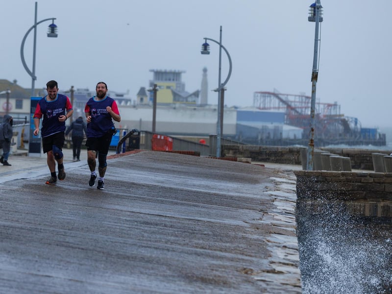 The stormy sea at high tide crashed waves onto footpaths as passer-by's did their best to get out the way