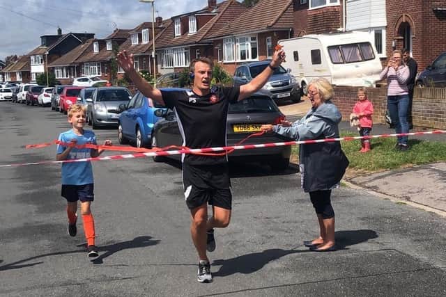Peter Sanderson completes his street marathon to raise money for AFC Portchester. Son, Joshua Sanderson, 8, joined him for the final mile of his run.