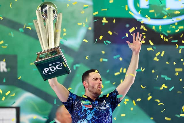 Luke Humphries lifts the trophy after winning the 2023/24 Paddy Power World Darts Championship. Pic: Tom Dulat/Getty Images)