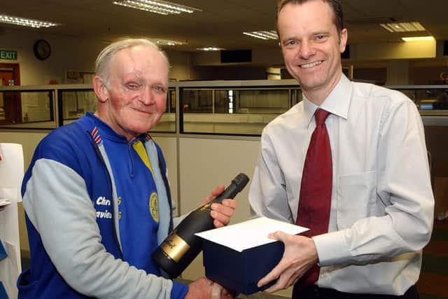 hris Davies is presented with champagne and a tankard from News editor Mike Gilson in recognition of his 50 years service to the  paper in March 2004. Pic: Jon Brady.