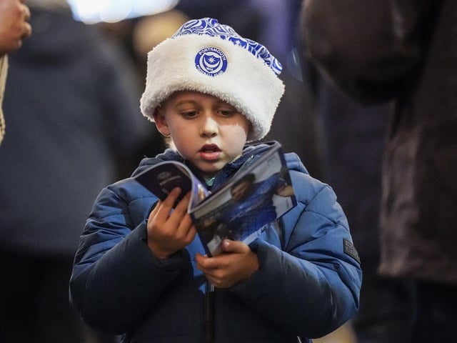 Flicking through the programme before kick-off.