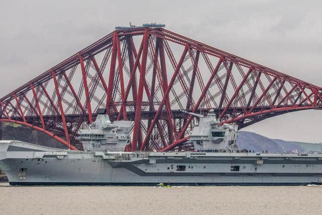 HMS Queen Elizabeth makes her way under the Forth Bridges as she prepared to dock at Rosyth in March