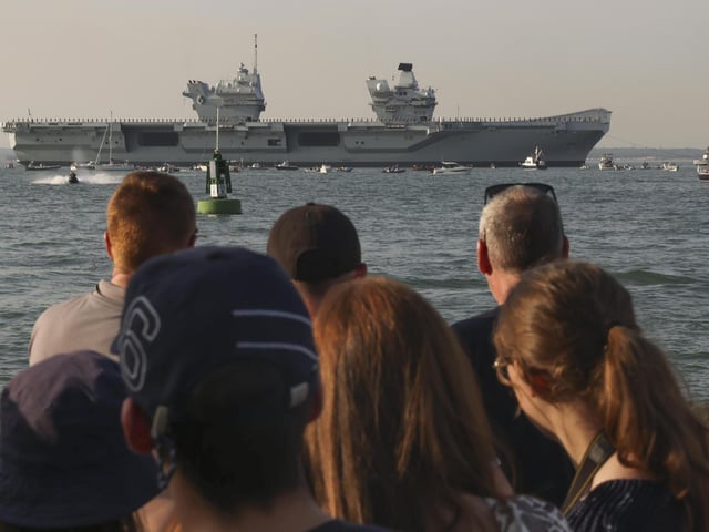 Pictured: HMS Queen Elizabeth enters the Solent off of Cowes and conducts a gun salute in front of the Royal Yacht Squadron.