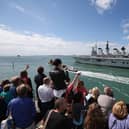 Relatives of navy personnel wave as the helicopter carrier HMS Illustrious departs Portsmouth for a deployment to the Mediterranean on August 12, 2013 in Portsmouth. Photo by Oli Scarff/Getty Images