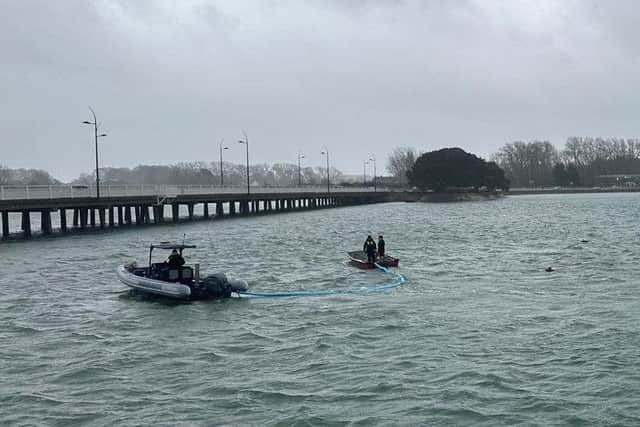 Harbour Teams deploy oil spill management equipment.