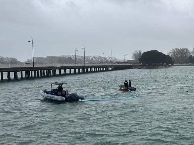 Harbour Teams deploy oil spill management equipment.