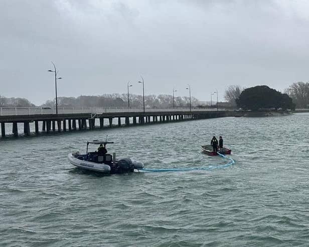 Harbour Teams deploy oil spill management equipment.