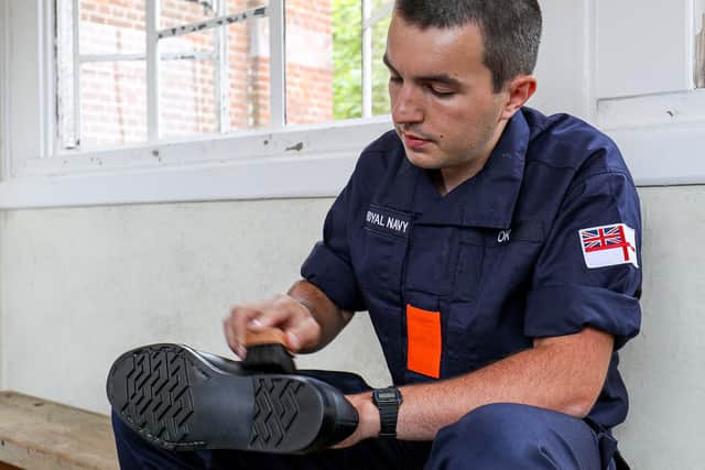 A recruit polishes his shoe at Britannia Royal Navy College