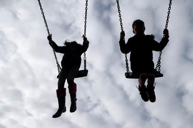 Children enjoy playing on swings in a park near amid a looming care crisis in Hampshire
