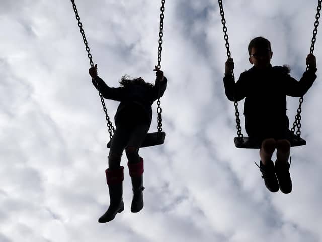 Children enjoy playing on swings in a park near amid a looming care crisis in Hampshire