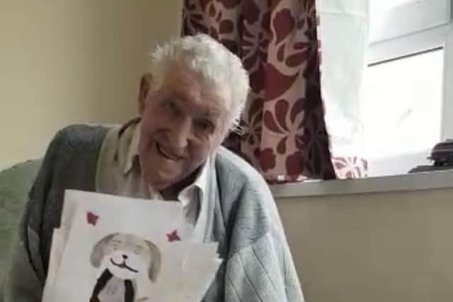 Arthur Bailey, 96, holding up some of the cards sent to him by children to celebrate his birthday. He is pictured with his dog.