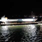 LCT 7074 makes its way past the Round Tower, lighting up the midnight sky. Picture: David George