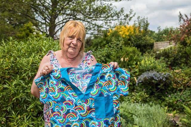 Lin Gell shows off one of the brightly coloured scrubs designed by Chris Evans and produced by Team Scubbers during the pandemic. Picture: Mike Cooter (080621)