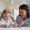 Smiling young mom and little foster daughter painting together: Image posed by models Picture: Adobe Stock