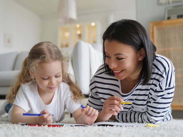 Smiling young mom and little foster daughter painting together: Image posed by models Picture: Adobe Stock