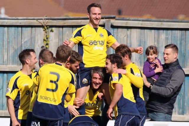 Justin Bennett is hoisted into the air by his Gosport Borough team-mates after breaking the club's scoring record in 2014 Picture: Adam Rivers