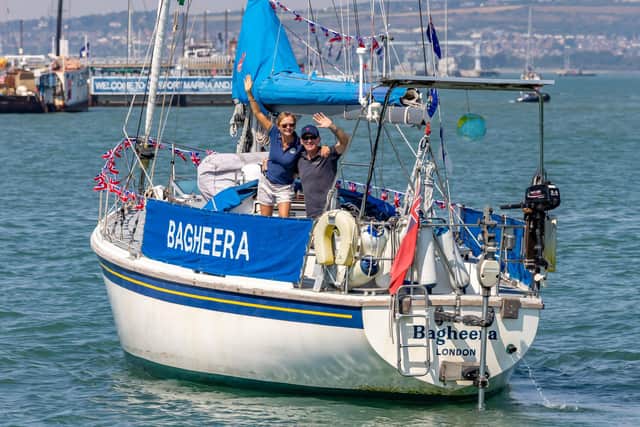Sally Titmus (56) and Paul Thompson (57) wave to family and friends at the entrance to Portsmouth Harbour after being away for four years. Picture: Mike Cooter (130822)
