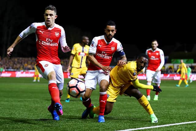Ross Worner got some good business off the back of Sutton's FA Cup tie with Arsenal in 2017/18. Here, Roarie Deacon - now Worner's team-mate at Westleigh Park - battles for possession with Theo Walcott and Gabriel Paulista. Photo by Clive Rose/Getty Images.