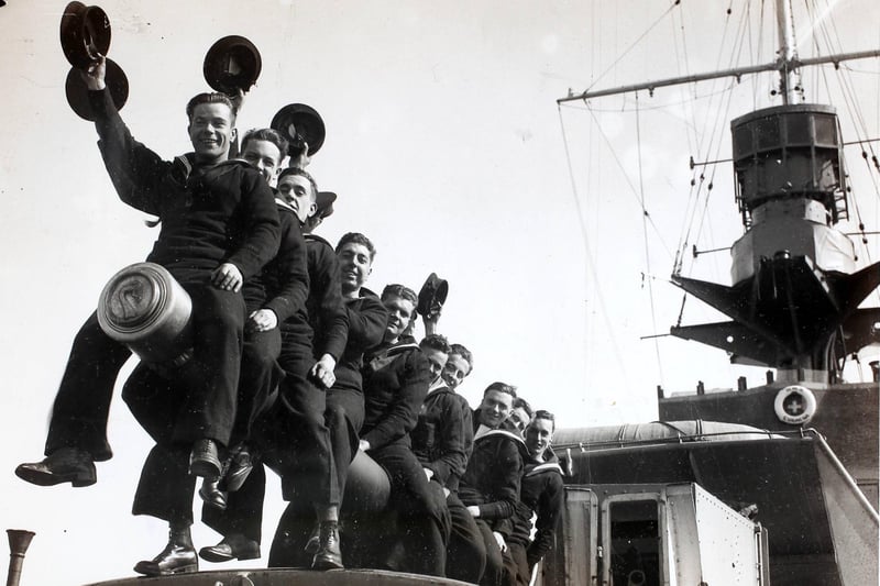 A group of RNVR (Royal Naval Volunteer Reserve) ratings raise a cheer on reaching Plymouth, England on the 'HMS Curacoa'. Officers and ratings of the RNVR (London and Sussex Divisions) are spending Easter afloat - they left Portsmouth for Plymouth and Torbay and are carrying out practical training including gunnery during their cruise. (Photo by Fox Photos/Hulton Archive/Getty Images)