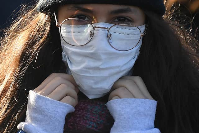 A woman wears a protective face mask as she crosses Westminster walks across Westminster Bridge in central London. Picture: DANIEL LEAL-OLIVAS/AFP via Getty Images