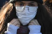 A woman wears a protective face mask as she crosses Westminster walks across Westminster Bridge in central London. Picture: DANIEL LEAL-OLIVAS/AFP via Getty Images