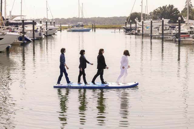 A Beatles tribute act recreate the band’s famous Abbey Road album cover on a giant SUP