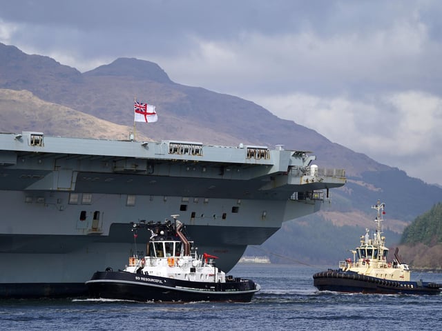 The Royal Navy aircraft carrier HMS Queen Elizabeth leaving Glen Mallan in Loch Long with the Arrochar Alps behind.
