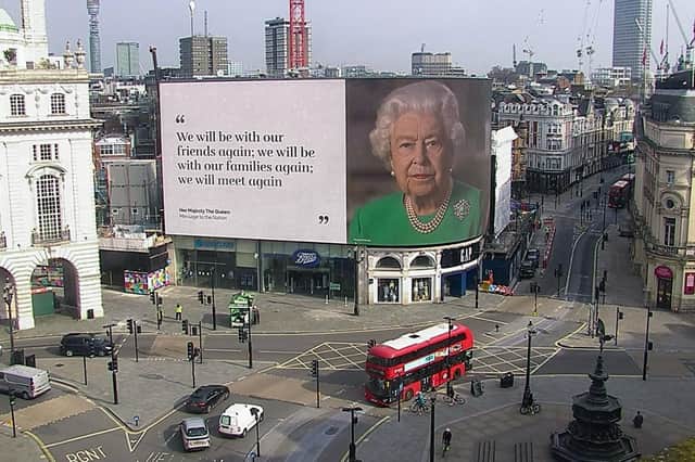 MEET AGAIN: The Queen during her emergency broadcast as seen in Piccadilly Circus Picture: Ocean Outdoors/PA Wire