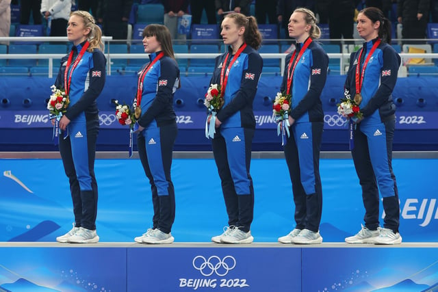 Milli Smith, Hailey Duff, Jenn Dodds, Vicky Wright and Eve Muirhead on the podium as the national anthem is played
