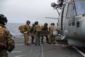 The casualty is transferred to a Merlin helicopter for the flight to HMS Queen Elizabeth