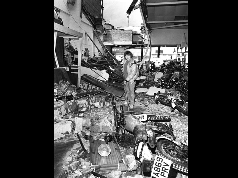 Office worker Carse Louth clears rubble at the Honda Centre, New Road, Portsmouth after it crashed through the roof on to the new motorcycles in October 1987. The News PP4121
