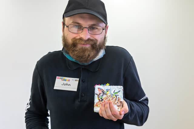 John Spinks (30) with one of the fundraiser slate cosaters he created using the decoupage technique. Picture: Mike Cooter (311021)