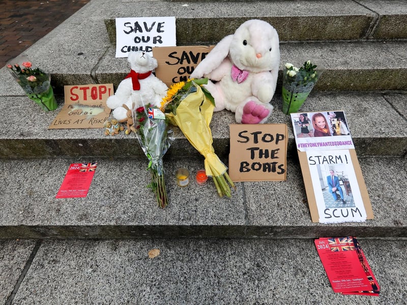 Protestors at Guildhall Square, Portsmouth. Flowers were left for the victims of the Southport killings, donning slogans such as "stop the boats" and describing prime minister Sir Keir Starmer as "scum". Picture: Chris  Moorhouse (030824-39)
