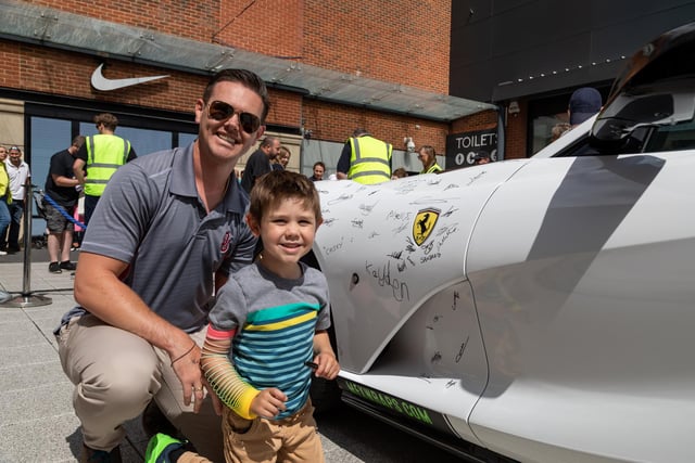 Kayden Breen (4) with dad Seth Breen (33) from Virginia USA added their signatures to the Ferrari. 
Picture: Mike Cooter (290723)