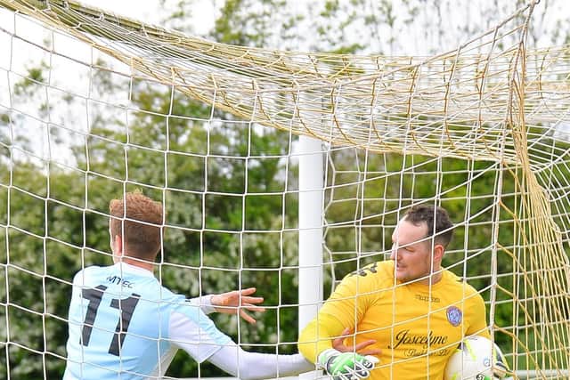 James Franklyn tries to get the ball off keeper Shane Murphy after scoring for USP against Hamworthy.  Picture: Martyn White.