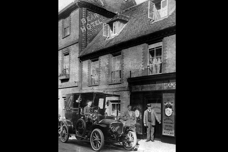 Chauffeurs waiting for guests outside the Bear Hotel, East Street, Havant. The gentlemen next door are at a wholesale shop selling Irish and Scotch Whiskies, Champagnes, Bordaeux and Burgundies and Hocks.
