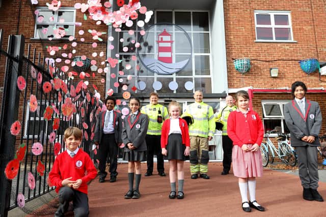 School children, from left, Maks Sikarjov, 8, Robson Yusef, 10, Fatima Hassawi, 9, Bella-Mae Mills, 6, Brooke Tappenden, 8, and Fri Achiri, 9, with firefighters, rear, left to right, firefighter Nico Razzell, firefighter Bill Cutler and crew manager Jamie Kelly with the children's Remembrance poppy installation at Ark Ayrton Priamry Academy, Somers Road, Southsea. The fire service helped with the installation work at the school
Picture: Chris Moorhouse   (jpns 101121-)