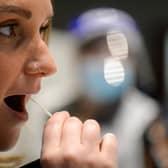 A woman takes the lateral flow test on February 22 at the Guildhall test site in Portsmouth. (Photo by Finnbarr Webster/Getty Images)