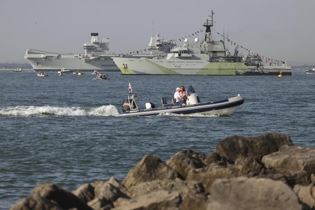 Pictured: HMS Queen Elizabeth enters the Solent off of Cowes passing HMS Tyne and conducts a gun salute in front of the Royal Yacht Squadron.
