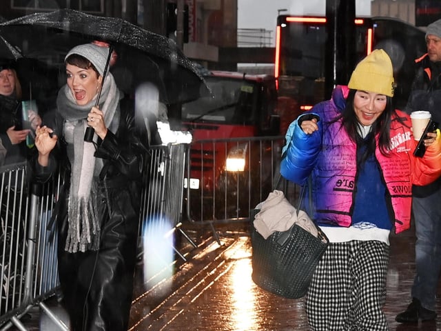 Dancers Lauren Oakley and Nancy Xu arrive in the heavy rain.
